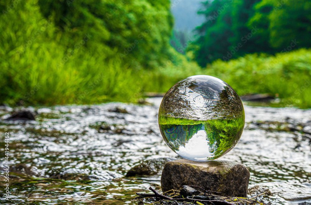 Ball of water sitting on rock in nature